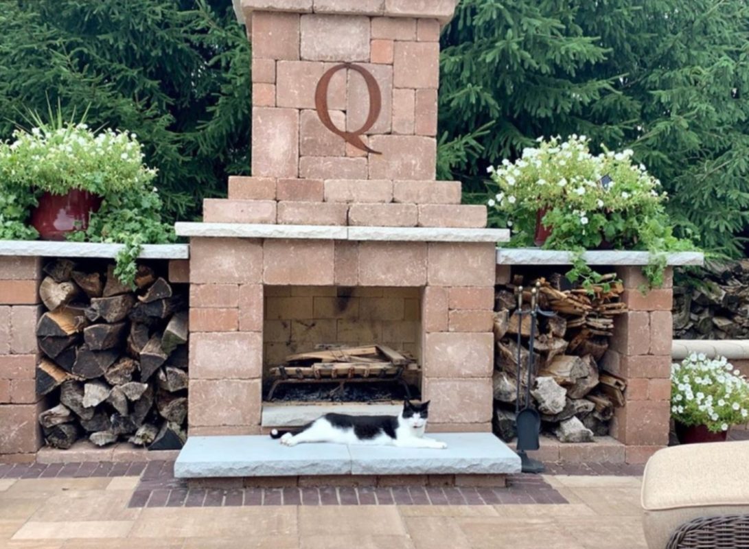 Brick outdoor fireplace with kitty